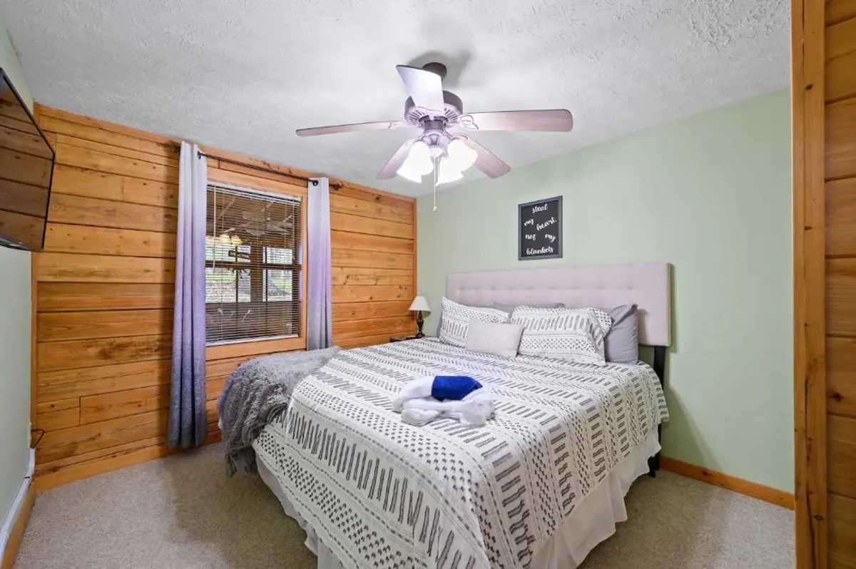 A serene bunk area featuring built-in twin beds, a wooden accent wall, a window letting in natural light, and a decorative sign. The scene suggests a peaceful place for relaxing, reading, or making memories, with a focus on comfort and togetherness.
